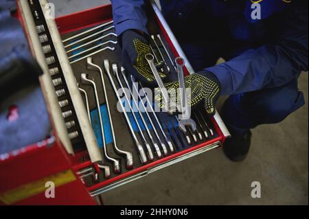 Ansicht von oben über einem Werkzeugsatz von Schraubenschlüsseln und Köpfen zum Lösen von Muttern und Schrauben in einem speziellen Schrank für RE Stockfoto