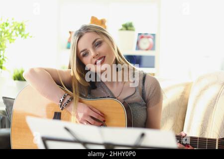 Inspiriert hübsche Frau Musikkomponistin, blonde Mädchen spielen auf der Gitarre Stockfoto