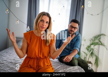 Traurige, nachdenkliche Paare, die an Beziehungsprobleme denken, die auf dem Sofa sitzen, Konflikte in der Ehe. Stockfoto