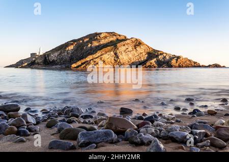 Kleine Insel in der Nähe von Mumbles Head und Leuchtturm bei Sonnenuntergang, Gower Peninsula, South Wales, Großbritannien Stockfoto