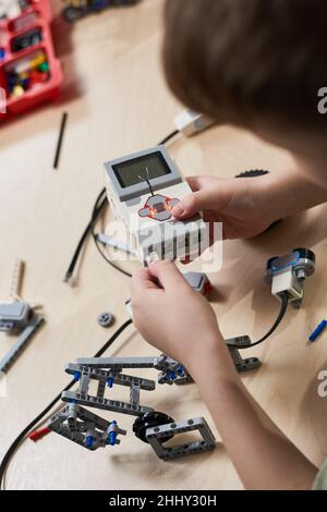 Nahaufnahme des jungen Bauroboters aus den Kunststoffen Details Programmierung auf dem Computer in der Robotik-Schule Lektion Stockfoto