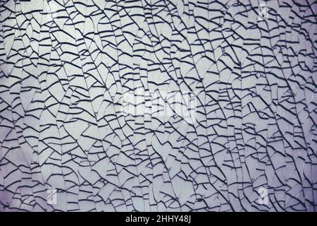 Blauer Hintergrund von Rissen auf gebrochenem Glas, Textur Stockfoto
