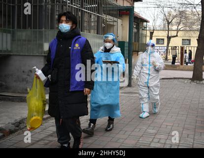 (220126) -- TIANJIN, 26. Januar 2022 (Xinhua) -- Huang Xinyi (R) geht zusammen mit anderen Mitarbeitern zur Durchführung von Nukleinsäureproben für Bewohner im nordchinesischen Tianjin, 20. Januar 2022. Tianjin startete am 20. Januar um 6 Uhr seinen vierten stadtweiten COVID-19-Nukleinsäuretest. Doktor Huang Xinyi, der zum zweiten Mal an den stadtweiten Nukleinsäuretests teilnahm, war zusammen mit sieben Kollegen für die Teststelle der Guanyun Grundschule im Bezirk Hedong in Tianjin verantwortlich. Huang Xinyi wurde in Kaohsiung im südöstlichen Taiwan geboren und kam an die Fujian University of Traditional C Stockfoto