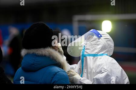 (220126) -- TIANJIN, 26. Januar 2022 (Xinhua) -- Huang Xinyi (R) sammelt eine Abstrichprobe von einem Bewohner für den COVID-19-Test an einer Teststelle im Bezirk Hedong im nordchinesischen Tianjin, 20. Januar 2022. Tianjin startete am 20. Januar um 6 Uhr seinen vierten stadtweiten COVID-19-Nukleinsäuretest. Doktor Huang Xinyi, der zum zweiten Mal an den stadtweiten Nukleinsäuretests teilnahm, war zusammen mit sieben Kollegen für die Teststelle der Guanyun Grundschule im Bezirk Hedong in Tianjin verantwortlich. Huang Xinyi wurde in Kaohsiung im südöstlichen Taiwan geboren und kam an die Fujian University of Tradit Stockfoto