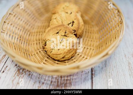 Köstliche Haferflocken-Kekse mit Rosinen in einem Weidenkorb Stockfoto