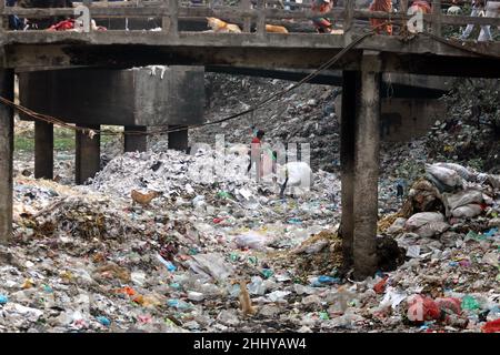 Dhaka, Bangladesch, 25. Januar 2022. Die Menschen gehen über eine Brücke über ein verschmutztes Gebiet, und Kinder gehen über ein verschmutztes Gebiet, während sie Plastikmaterialien sammeln in Dhaka, Bangladesch, 25. Januar 2022. Foto von Habibur Rahman/ABACAPRESS.COM Stockfoto