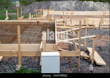 Bau eines Wohnhauses mit angrenzender Garage mit dem Bau eines Fundaments und der dazugehörigen Schalung aus Holz Stockfoto