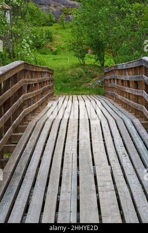 VALLDAL, NORWEGEN - 2020. JUNI 06. Brücke über den Fluss im Wald. Stockfoto