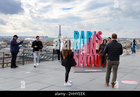Paris, Frankreich. 20th Oktober 2021. Touristen fotografieren sich vor dem Hintergrund der französischen Hauptstadt mit dem Eiffelturm und dem überdimensionalen Schriftzug „Paris Mon Amour“ auf dem Dach des Flagship-Stores der Kaufhauskette der Galleries Lafayette. Quelle: Jan Woitas/dpa-Zentralbild/ZB/dpa/Alamy Live News Stockfoto