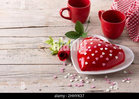 Herzförmiger Kuchen zum Valentinstag oder Muttertag auf einem Holztisch Stockfoto