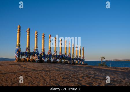 Bunte Bänder auf den Holzsäulen in der heiligen burjat Platz auf Kap Burkhan in Khuzhir Dorf in Olchon Insel, Baikalsee, Russland Stockfoto