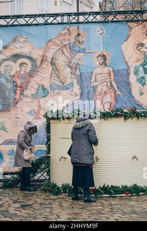 Lviv, Ukraine - 19. Januar 2022 : Epiphanie, orthodoxer Feiertag. Menschen sammeln geweihtes Weihwasser in Flaschen und Behältern, um es nach Hause zu bringen Stockfoto