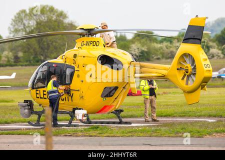 Gelber WPD-Hubschrauber, der in der Stromverteilungsbranche für die Netzwartung/-Reparatur-Betankung am Halfpenny Green Airport, Staffs, Großbritannien, eingesetzt wird. Stockfoto