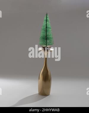 Weihnachtsbaum mit einem goldenen Glas Champagner. Minimales Neujahrskonzept. Stockfoto