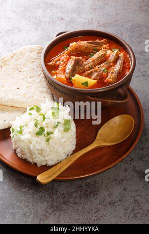 Hilachas ist ein traditioneller guatemaltekischer Eintopf mit geschreddertem Rindfleisch, das in einer leicht gewürzten Tomatensauce mit zarten Kartoffeln in der Nähe auf dem Teller gekocht wird Stockfoto