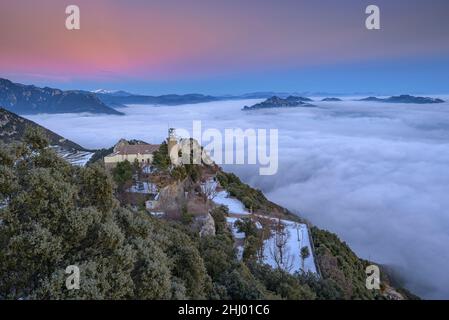 Queralt Sanctuary in einem Winter Sonnenuntergang mit einem Meer von Wolken über Berga (Berguedà, Katalonien, Spanien, Pyrenäen) ESP: Santuario de Queralt al atardecer Stockfoto