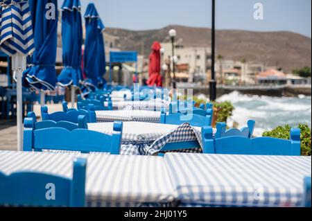 Blaue Stühle und Tisch am Meer, typisch griechische Taverne in Kissamos, Kreta, Griechenland. Traditionelles Ambiente in einem griechischen Restaurant am Meer. Stockfoto