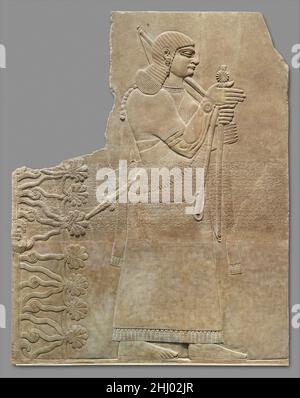 Entlastungsblech ca. 883–859 v. Chr. Assyrer die bärtlose männliche Figur, die auf dieser Tafel aus dem Nordwest-Palast in Nimrud (altes Kalhu) abgebildet ist, ist mit ziemlicher Sicherheit ein Eunuch. Viele solcher Figuren erscheinen in der assyrischen Kunst, da Eunuchen im Mittelpunkt des höfischen Lebens standen. Da sie selbst keine Kinder haben konnten, wurden Eunuchen im Allgemeinen als weniger eine Bedrohung für den König und seine Dynastie wahrgenommen; jedoch wurden einige Eunuchen enorm mächtig. Die in der Nähe des Königs dargestellten Figuren werden oft mit spezifischen Funktionen dargestellt, in diesem Fall mit der eines Waffenträgers: Die Figur trägt eine Keule, einen Bogen, einen Köcher aus Pfeilen und einen Schwor Stockfoto