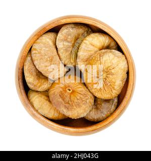 Getrocknete Feigen in einer Holzschale. Sonnengetrocknete, reife und ganze Feigen, essbare und ungekochte Früchte von Ficus carica, einem beliebten Snack im Winter. Stockfoto