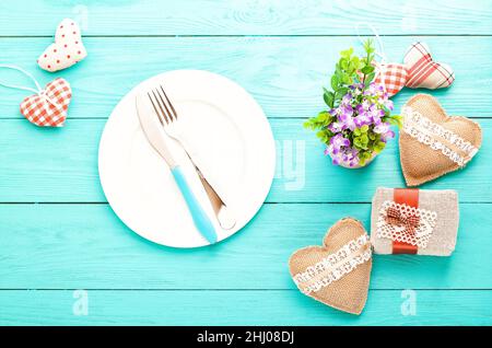Romantisches Abendessen, Blumen und Herzen auf Holzhintergrund. Modell Stockfoto