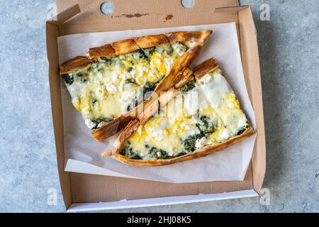 Traditionelle türkische Küche zum Mitnehmen Pide mit Spinat, Käse und Ei in Box. Bereit zum Essen. Stockfoto