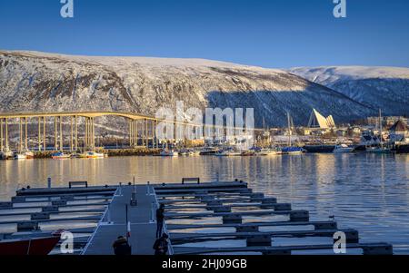 Der Hafen von Tromsø und die arktische Kathedrale an einem sonnigen Winternachmittag (Tromsø, Norwegen) ESP: Puerto de Tromsø, y Catedral del Ártico en una tarde soleada Stockfoto