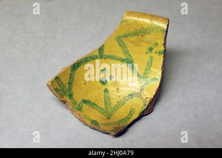 Fragment einer Schüssel 9th Jahrhundert. Fragment einer Schüssel. 9th Jahrhundert. Steingut; Buff Slip, opake gelbe Glasur, grüne Dekoration, glasiert. Ausgegraben in Iran, Nishapur. Keramik Stockfoto