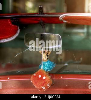 Nostalgisches rotes Cabrio mit Hula Girl und unscharfem Würfel Stockfoto