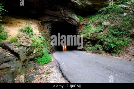 Ein Auto mit Scheinwerfern, die aus einem Tunnel kommen Stockfoto