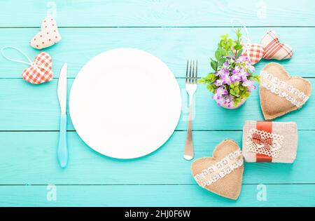 Romantisches Abendessen, Blumen und Herzen auf Holzhintergrund. Modell Stockfoto