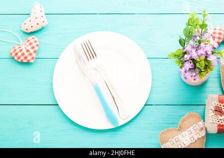 Romantisches Abendessen, Blumen und Herzen auf Holzhintergrund. Modell Stockfoto