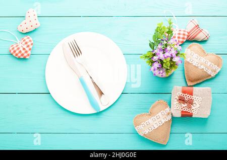 Romantisches Abendessen, Blumen und Herzen auf Holzhintergrund. Modell Stockfoto