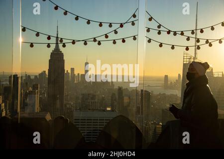 Eine Frau blicks vom Rockefeller Center auf Manhattan und das Empire State Building Stockfoto