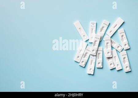 Positiver Covid-19-Antigentest. Coronavirus-Antigen-Schnelltest auf blauem Hintergrund. Draufsicht. Stockfoto