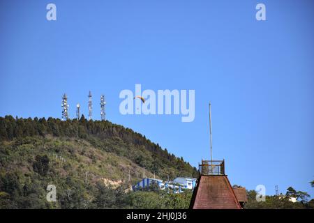 Paragliding in Kalimpong vom Deolo Hügel in Kalimpong, blauer Himmel und Kirchturm Stockfoto