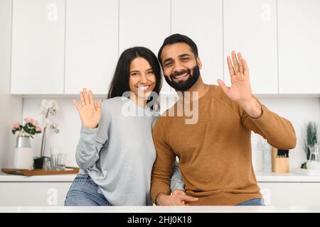 Glückliches schönes junges indisches Paar zusammen zu Hause. Ethnische junge Frau umarmte ihren Mann, während sie sich in einer modernen Wohnung ausruhte. Porträt eines romantischen multirassischen Paares in der Liebe Stockfoto