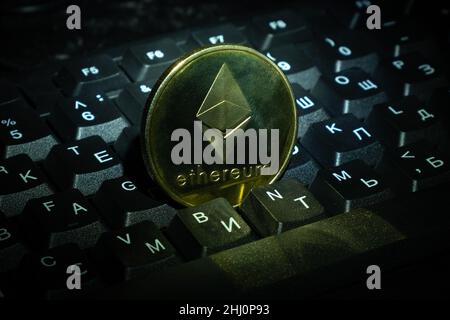 Goldmünze Ethereum (ETH) auf der Tastatur Nahaufnahme Kryptowährung einkaufen und Geld verdienen online. Stockfoto