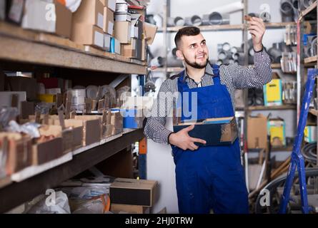 Arbeiter prüft kleine Details für die Sanitäringenieurwesen in der Werkstatt Stockfoto