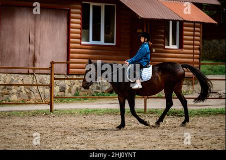 Woiwodschaft, Ukraine 4. Mai 2021: Ausbildung zum Reiten, Reiten, ein Mädchen lernt, ein Pferd zu reiten, das Mädchen sitzt in einem Sattel und in einer Spezie Stockfoto