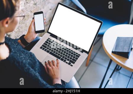 Crop Frau mit Laptop und Smartphone, während im Café sitzen Stockfoto