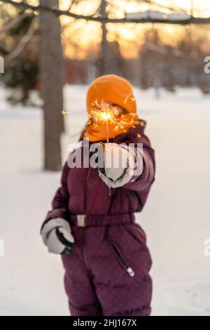 Nettes Mädchen hält einen Funkler im Winter im Wald Stockfoto