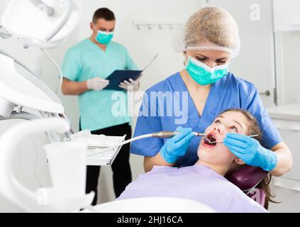 Weibliche Zahnärztin mit Patientin während der oralen Untersuchung Stockfoto