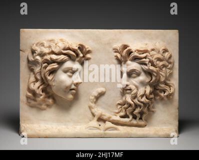 Marmor zweiseitiges Relief 1st Jahrhundert A.D. Roman die peristyle Gärten der römischen Häuser und Villen wurden mit dekorativen Marmorreliefs wie diesem gefüllt. Die Masken einer jungen Maenade und eines bärtigen silenus sind auf einer Seite in Hochrelief geschnitzt. Ein Hirtenknäuel, in der Antike als Pedum bekannt, und zwei Zimbeln ruhen zwischen ihnen. Dionysiac-Kultobjekte und Theatermasken sind oft auf ähnlichen Marmorornamenten abgebildet, die in Pompeji gefunden wurden, wo sie zwischen den Säulen des Peristyls aufgehängt oder auf hohen Säulen um den Garten herum aufgestellt wurden. Andere Themen sind jedoch auch vertreten; auf der ot Stockfoto