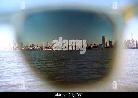 Das Empire State Building und Midtown Manhattan wurden durch eine polare Sonnenbrillen-Linse und einen Rahmen aufgenommen, die von der anderen Seite des Hudson River aufgenommen wurden Stockfoto