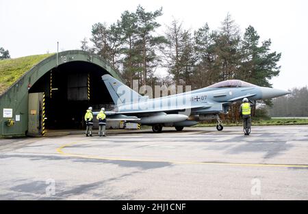 Wittmund, Deutschland. 26th Januar 2022. Ein Kampfflugzeug der Luftwaffe Eurofighter Typhoon wird aus einem Hangar auf dem Luftwaffenstützpunkt Wittmundhafen vertrieben. Aufgrund einer umfassenden Sanierung des Flugstützpunktes in Wittmund, Ostfriesland, verlegt die Bundeswehr vorübergehend 19 Eurofighter von dort auf den Stützpunkt Laage südlich von Rostock in Mecklenburg-Vorpommern. Quelle: Hauke-Christian Dittrich/dpa/Alamy Live News Stockfoto