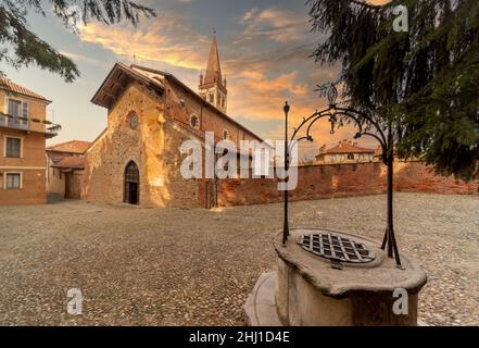 Saluzzo, Cuneo, Italien - 19. Oktober 2021: Die Kirche San Giovanni (14. Jahrhundert), Sitz der Serviten-Väter in der Via San Giovanni mit altem Brunnen Stockfoto