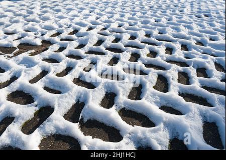 Sich wiederholende Fischgrätschneemuster, die durch Leitungsunterschiede entstehen, Wärmedämmung in der Auffahrt dunkle Bereiche werden sich durch Sonneneinstrahlung schneller erwärmen Stockfoto