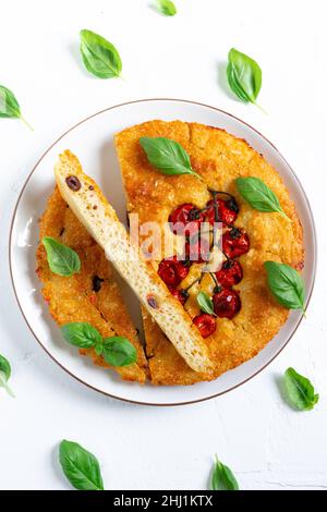 Frisch gebackene Focaccia mit Kirschtomaten auf einem Teller Stockfoto