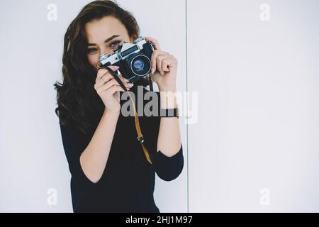 Junger Fotograf, der mit einer Retro-Fotokamera fotografiert Stockfoto
