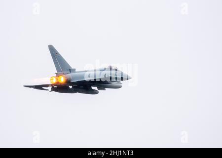 Wittmund, Deutschland. 26th Januar 2022. Ein Eurofighter Typhoon-Kämpfer der Luftwaffe hebt mit eingeschaltetem Nachbrenner vom Luftwaffenstützpunkt Wittmundhafen ab. Aufgrund einer umfassenden Sanierung des Flugstützpunktes in Wittmund, Ostfriesland, verlegt die Bundeswehr vorübergehend 19 Eurofighter von dort auf den Stützpunkt Laage südlich von Rostock in Mecklenburg-Vorpommern. Quelle: Hauke-Christian Dittrich/dpa/Alamy Live News Stockfoto